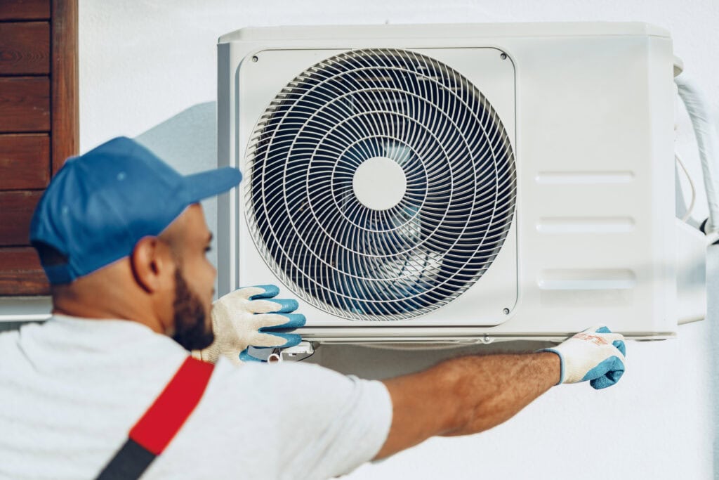Wortham Air Conditioning - Repairman Servicing AC Unit in Home