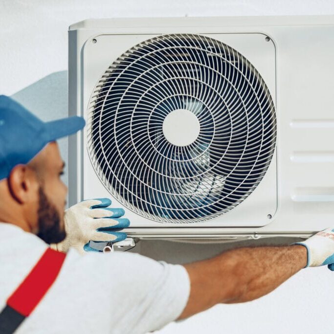 Wortham Air Conditioning - Repairman Servicing AC Unit in Home